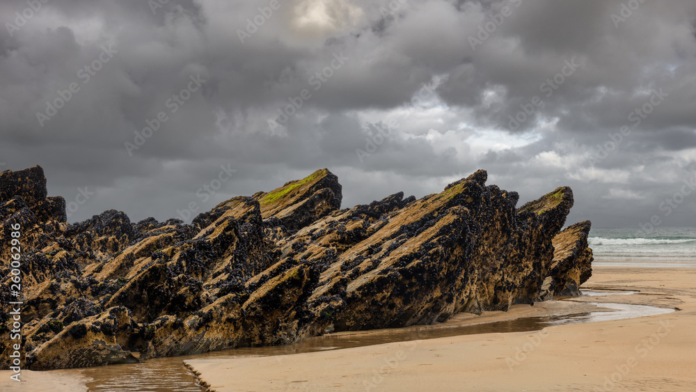 Dark clouds and light sand on the beach of Newquay in Cornwall Dark clouds and light sand on the beach of Newquay in Cornwall