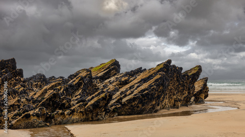 Dark clouds and light sand on the beach of Newquay in Cornwall