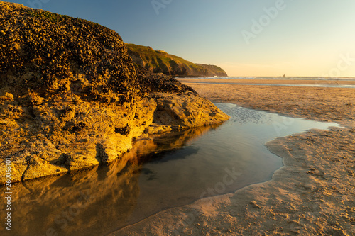 Fototapeta Naklejka Na Ścianę i Meble -  Beautiful sunset on the beach with reflections in the water at Perranporth in Cornwall, UK