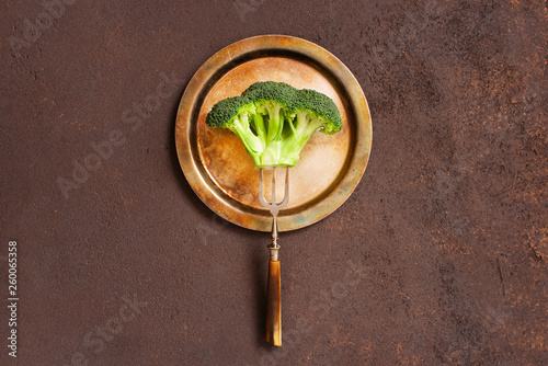 Broccoli on the vintage metal plate on the brown textured table