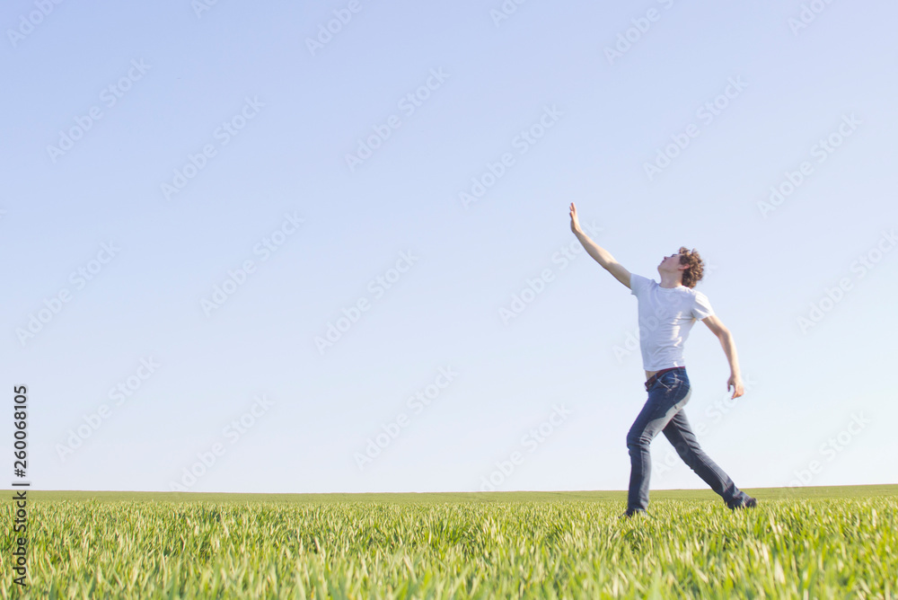 teenager running through a field of green wheat teenager running through a field of green wheat