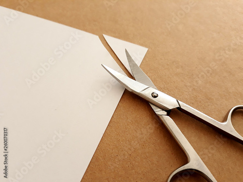 Cutting corners idiom Briticism hand takes sheet of paper and cutting corners by scissors doing something so easily and cheaply as possible 