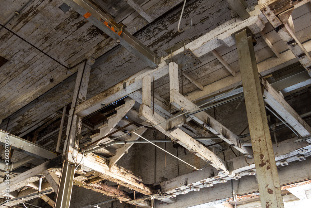 Looking up into the ceiling of an abandoned factory with wooden stairs Looking up into the ceiling of an abandoned factory with wooden stairs