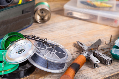 bright different fishing tackles on wooden background.