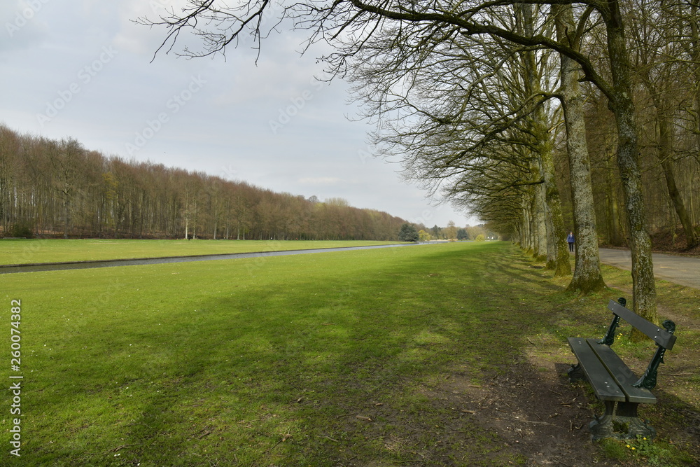 Obraz premium Banc le long de la grande pelouse longeant le canal qui relie les étangs au parc de Tervuren à l'est de Bruxelles