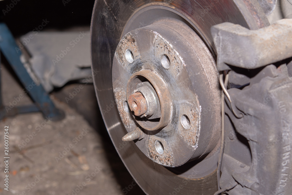 Car disk brakes repair service performed. Brake disk and a wheel hub.
