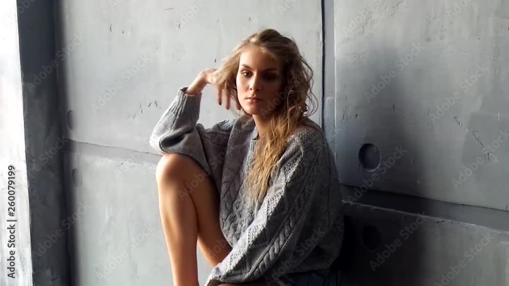 Beautiful girl posing against the background of a concrete wall Beautiful girl posing against the background of a concrete wall