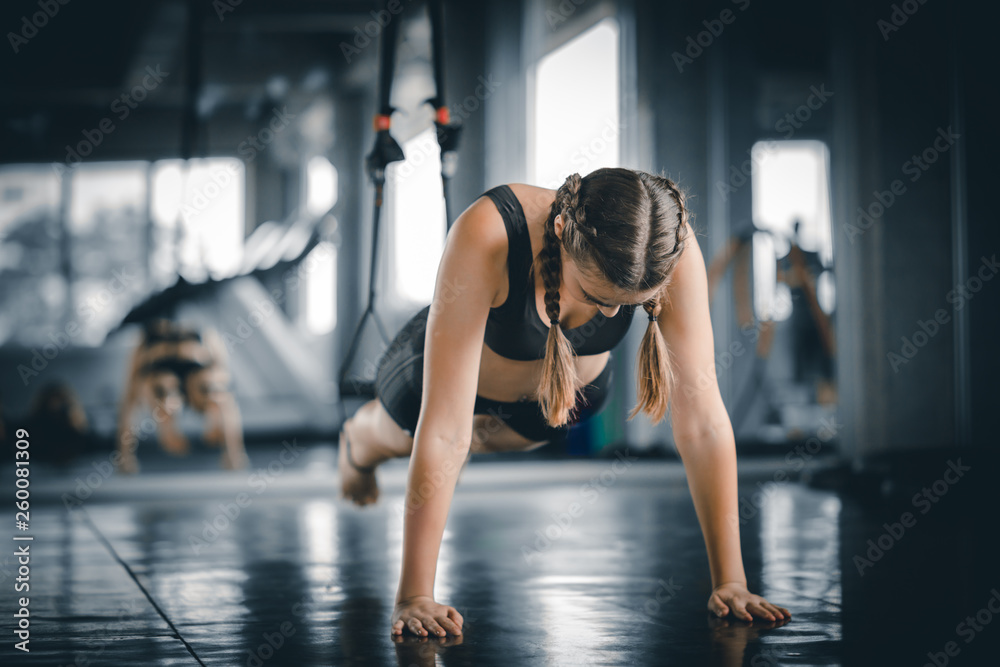 Fototapeta premium Portrait young attractive healthy woman body curve fitness doing push up at indoor workout in gym. People beauty perfect body slim fitness girl. Freedom happy and relax lifestyle healthcare concept.