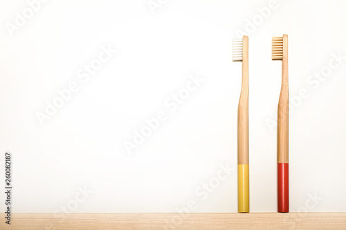 yellow and red colours bamboo toothbrushes on white background. Place for text. Ecoproduct. eco-friendly.