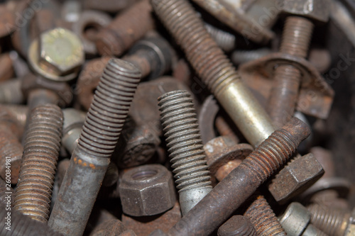Pile of old rusty screw heads, bolts, metal nuts. Bolt used overlapping full. Bolts and screws used in constructions.