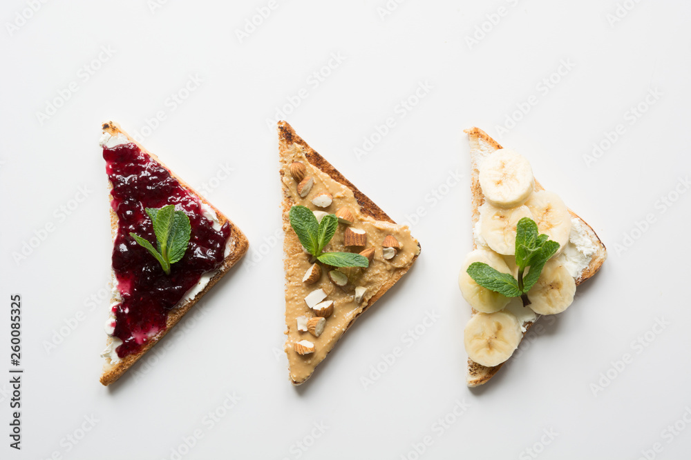 Different types of sandwiches for healthy and sugar-free children's breakfast, nut paste, bananas, berry jam.