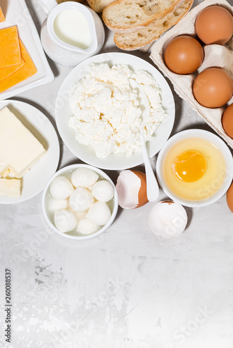 assortment of fresh dairy products on white background, vertical top view