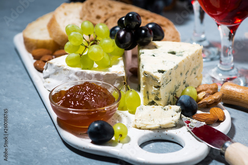 cheese plate, fresh grapes and red wine, closeup