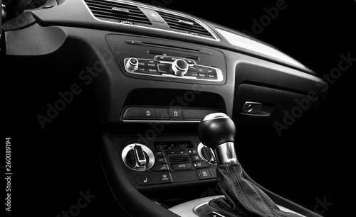 Modern Luxury car inside. Interior of prestige car. Black Leather. Car detailing. Dashboard. Media, climate and navigation control buttons. Sound system. Modern car interior details. Black and white