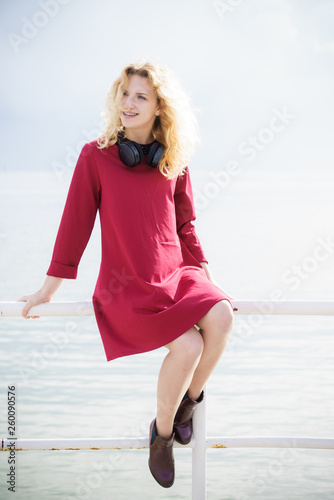 Woman wearing red dress and headphones