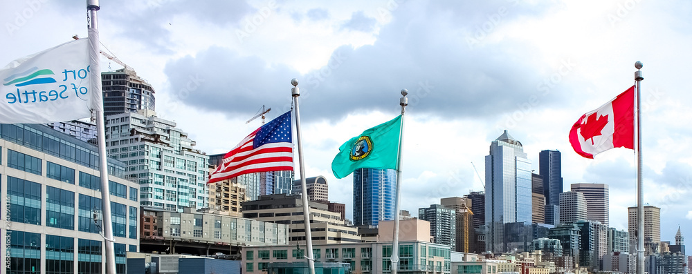 US Flag and Canada against the backdrop of the Seattle skyscrapers. Panoramic view US Flag and Canada against the backdrop of the Seattle skyscrapers. Panoramic view