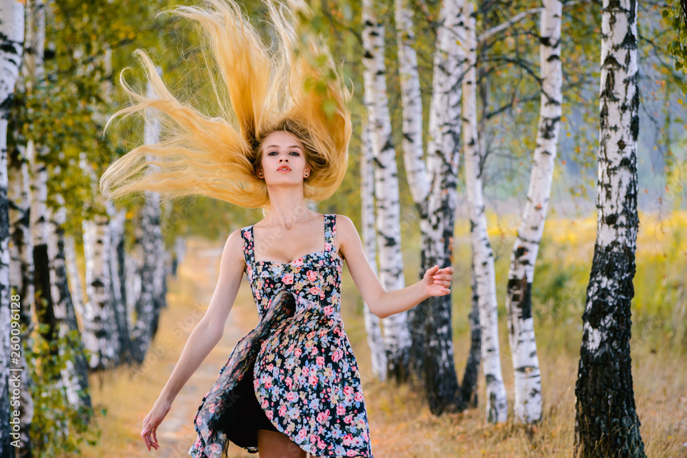 An attractive girl with fluttering hair and a short dress walks in the Park. An attractive girl with fluttering hair and a short dress walks in the Park.