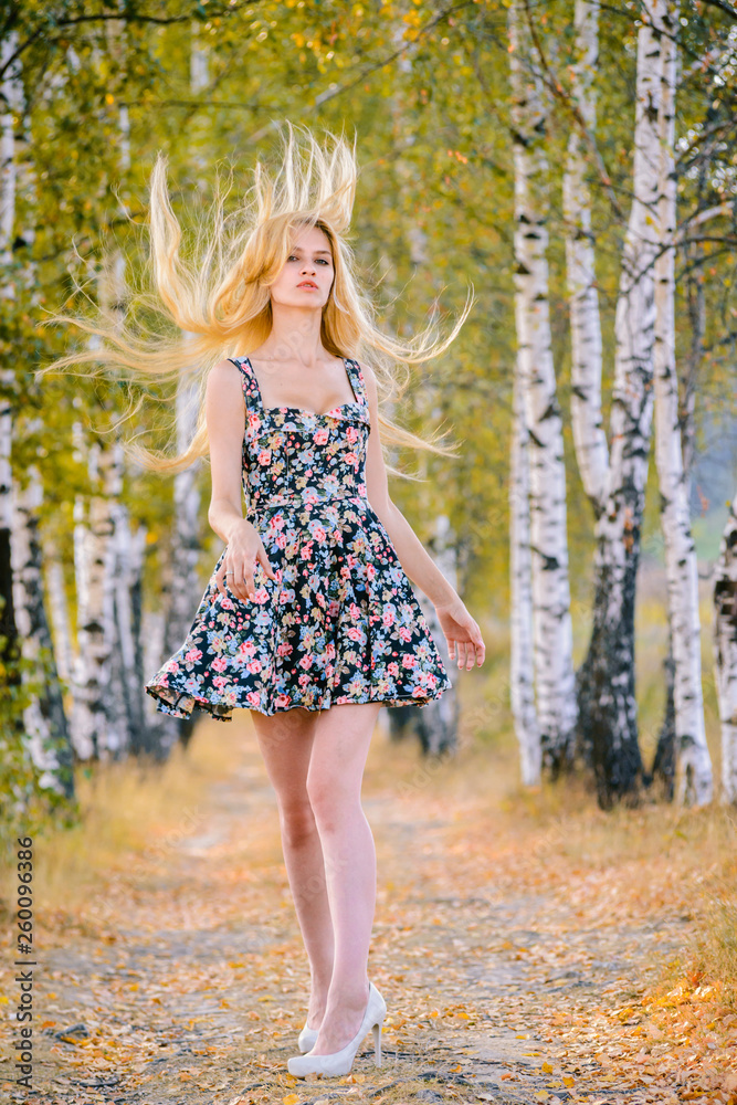 An attractive girl with fluttering hair and a short dress walks in the Park. An attractive girl with fluttering hair and a short dress walks in the Park.