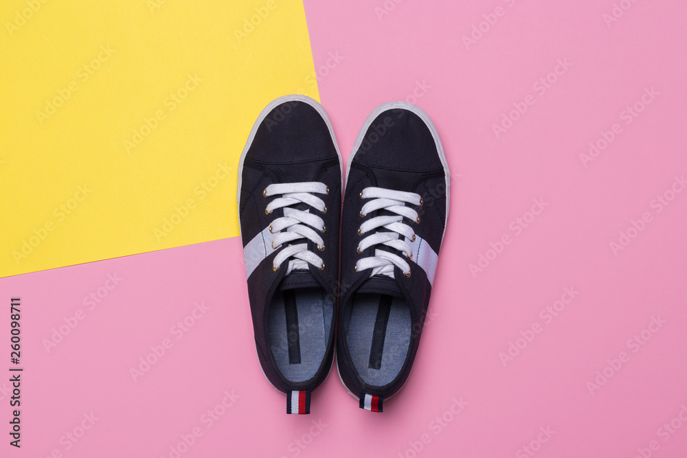 Sneakers on pink and yellow background. Fashion blog or magazine concept. Sneakers on pink and yellow background. Fashion blog or magazine concept.