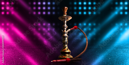 Hookah smoking on a dark abstract background. Background of empty scenes with neon lights and colored lights, reflection of night lights on wet asphalt