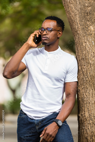 Outdoor portrait of a Young black African American young men talking on mobile phone