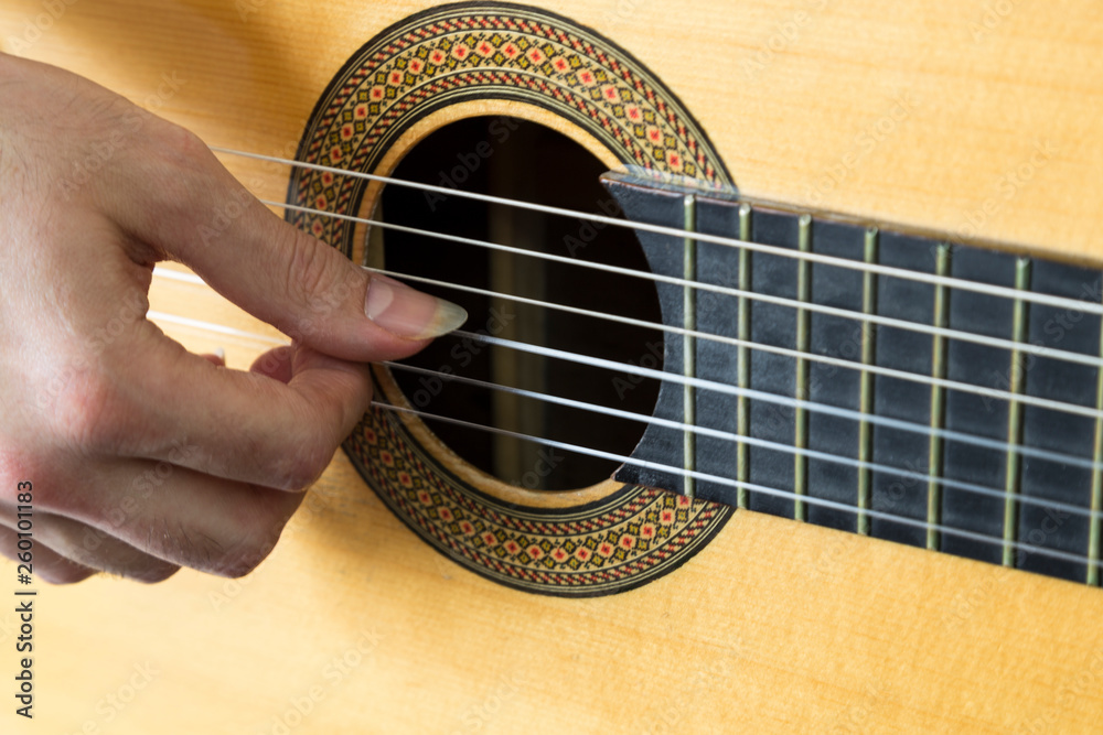 Obraz premium close up photo that the man play guitar with long nail finger.