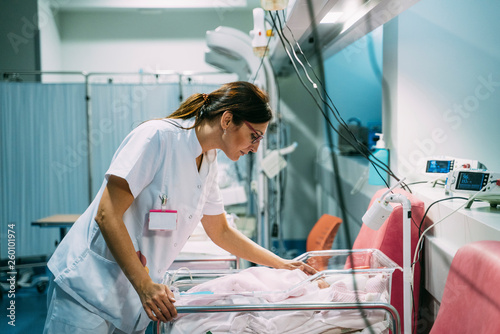Female doctor examining newborn baby in the hospital. Night shift