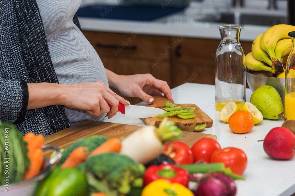 Pregnant woman preparing healthy food with lots of fruit and vegetables at home. Close-up. Pregnant woman preparing healthy food with lots of fruit and vegetables at home. Close-up.