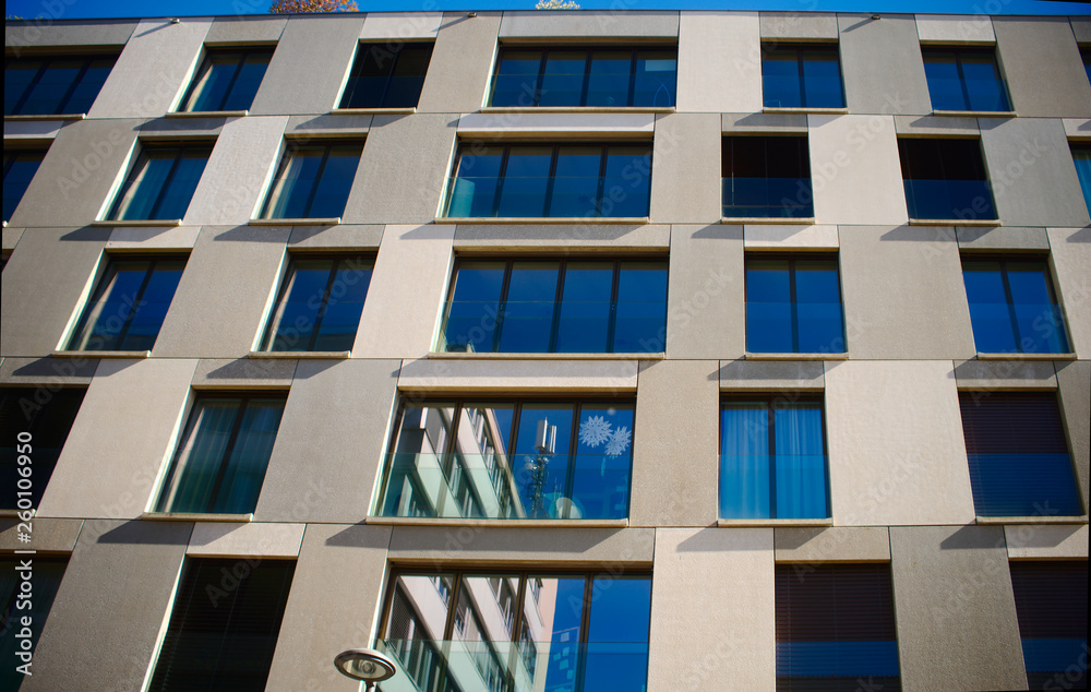Looking up to an urban window front against blue sky Looking up to an urban window front against blue sky