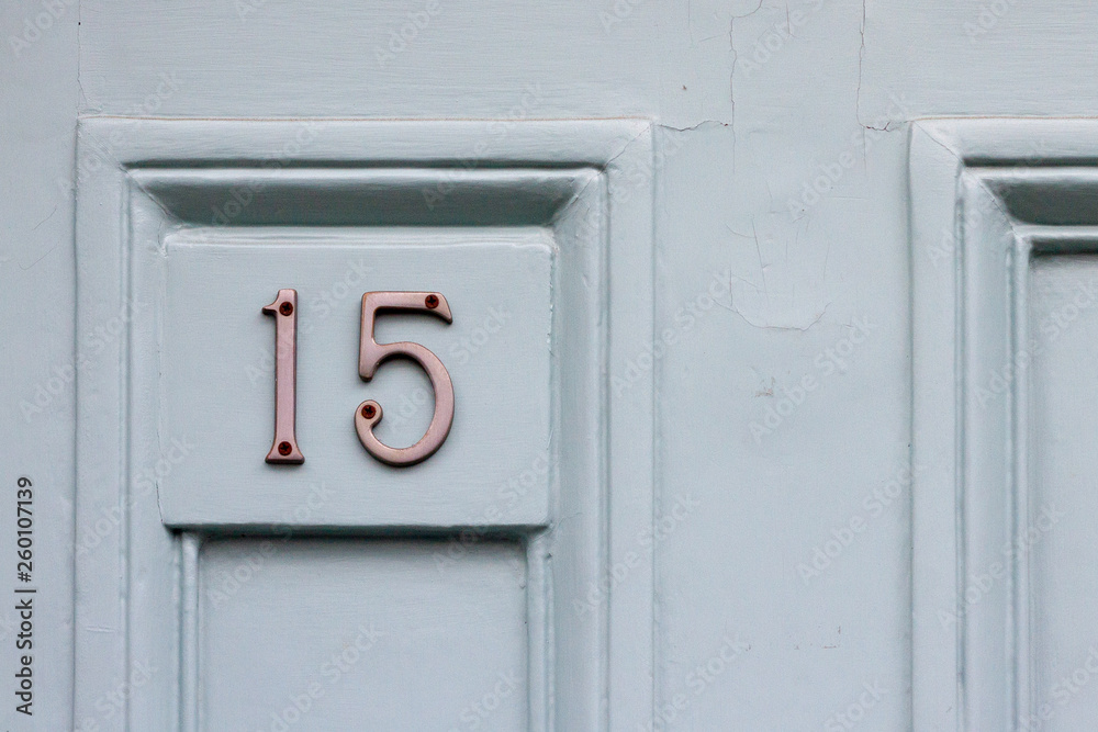 House door number fifteen with the 15 in silvery metal digits House door number fifteen with the 15 in silvery metal digits