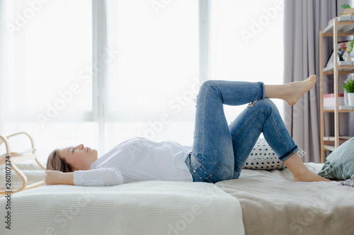 A blonde woman is on the bed