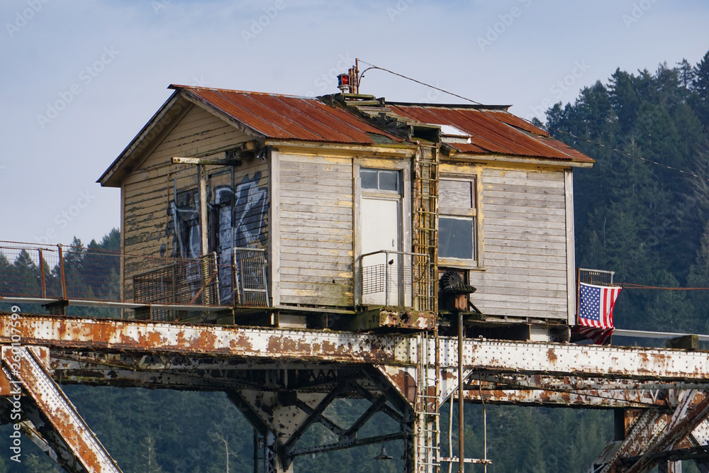 Bridge keeper’s station atop the Cushman swing span railroad bridge across the Siuslaw River at Mapleton, Oregon near Florence. The center span pivots to allow water navigation.