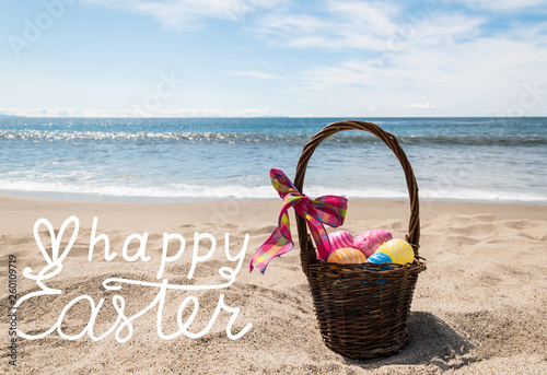 Canvas Print Easter bunny with color eggs on the ocean beach