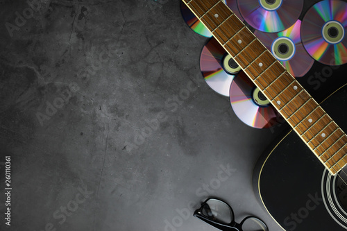 Guitar and accessories on a stone background. Desk musician, headphones, microphone. photo