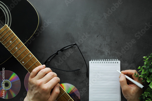 Guitar and accessories on a stone background. Desk musician, headphones, microphone. photo