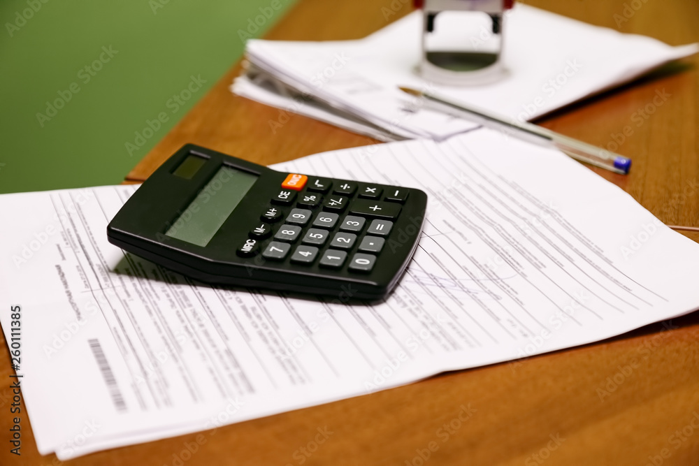 Black calculator with papers in the office Black calculator with papers in the office