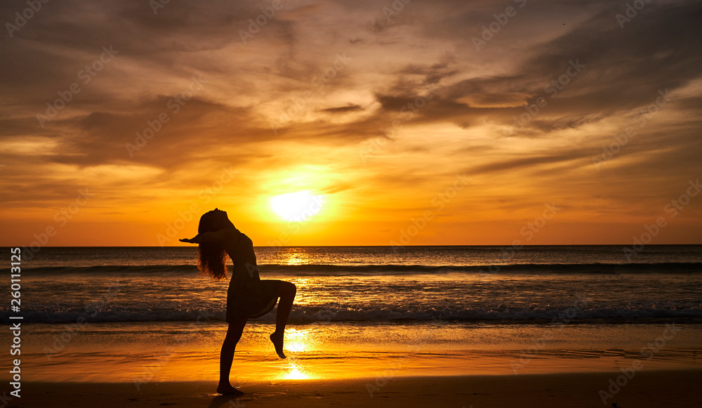 Girl on the beach during sunset doing yoga