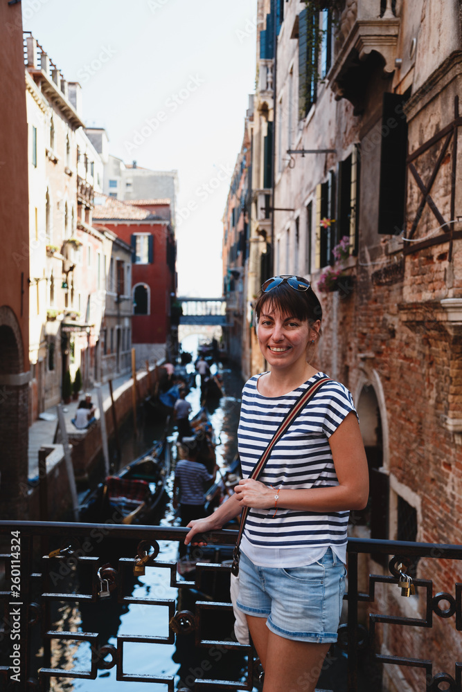 Young woman tourist standing on a bridge near rio del Vin canal in Venice, Italy. Travel concept