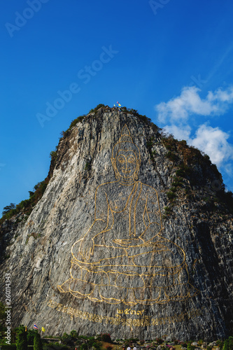 gold-carved buddha on the rock photo