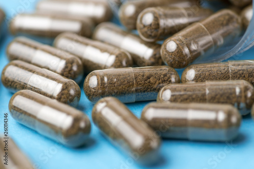 Brown pills, tablets on blue background. Close-up photography of tablets or pills.