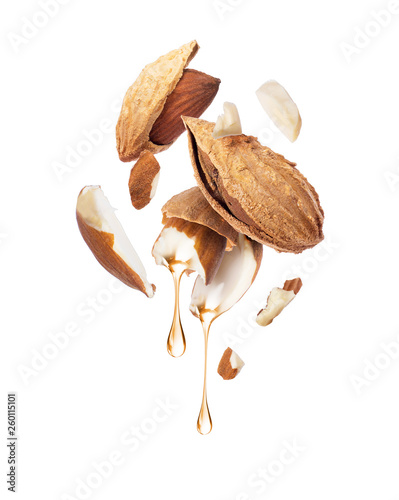 Photographie Drops of oil dripping from almond close-up on a white background
