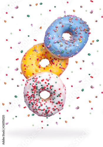 Sweet and colorful decorated donuts falling or flying in motion on an isolated white background