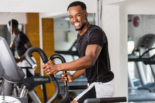 Black African American young man doing cardio workout at the gym