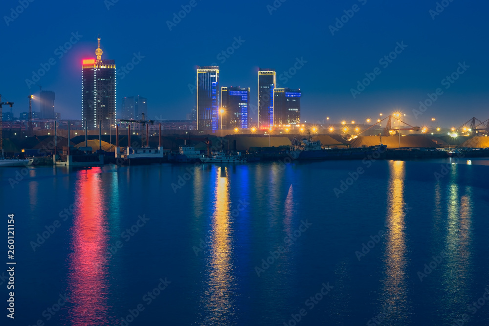 Cargo ship in port of Rizhao, China, inner harbor under deep blue twilight sky