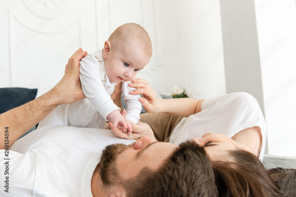 Young parents lay and hold baby girl Young parents lay and hold baby girl