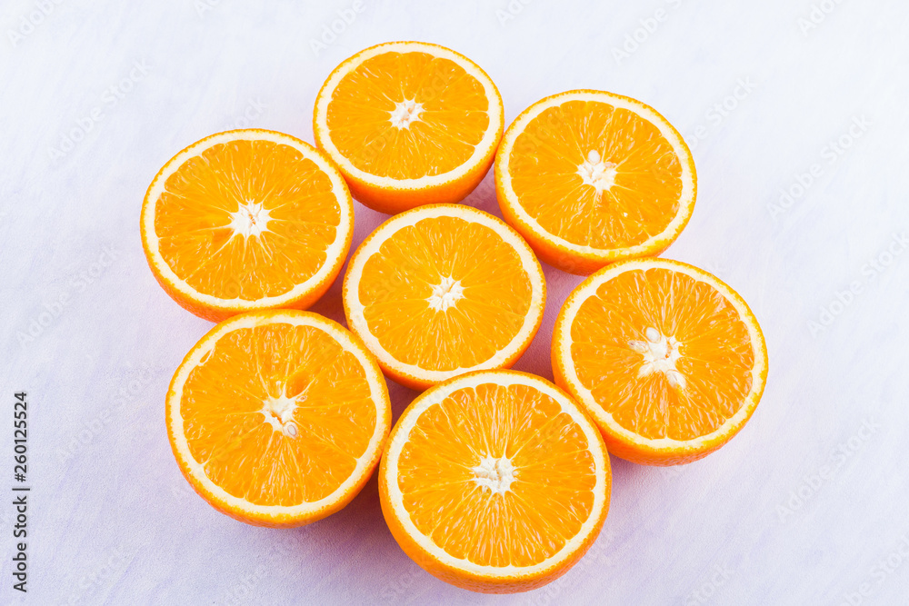 Sliced oranges fruit on white background. Citrus for making juice. Halved oranges creatively stacked on table. Background of oranges. Top view Sliced oranges fruit on white background. Citrus for making juice. Halved oranges creatively stacked on table. Background of oranges. Top view