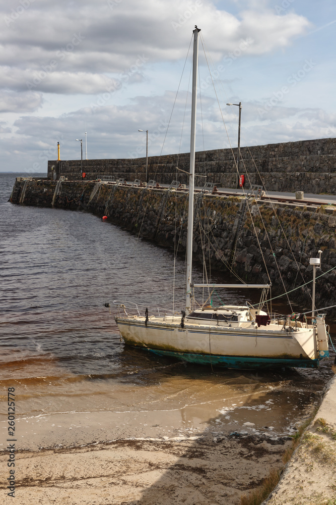 Boat at Pier and beach in Galway Bay