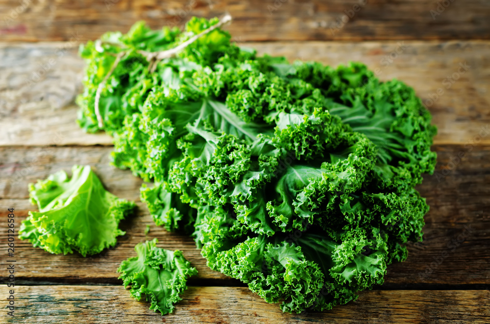 Fresh kale Bunch on a dark wood background Fresh kale Bunch on a dark wood background