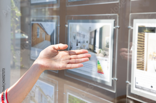 woman in front of real estate agent showcase window