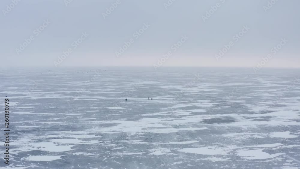 Northern aerial rising over fishing huts on frozen lakes Northern aerial rising over fishing huts on frozen lakes